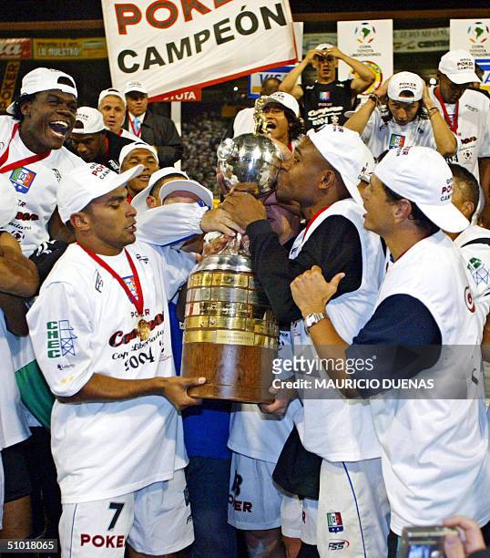 Colombia's Once Caldas players celebrate holding the Libertadores Cup trophy after defeating Argentina's Boca Juniors, 01 July 2004 in Manizales....