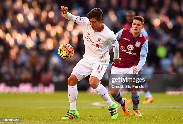 Roberto Firmino of Liverpool controls the ball under pressure from Ashley Westwood of Aston Villa during the Barclays Premier League match between...