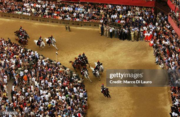 Italian Paramilitary Police "Carabinieri" horse patrol ride their horses in Piazza del Campo prior the start of the fifth trial called "general...