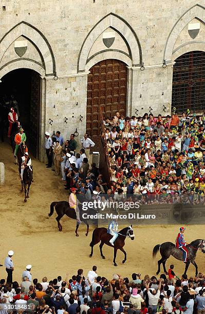 Jockeys, wearing the colours of their Contrade, ride their horses into Piazza del Campo during the fifth trial called "general trial, on July 1, 2004...