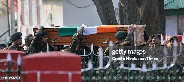 Army soldiers carry the coffins containing the bodies of their colleagues during a wreath laying ceremony to pay homage at a military garrison on...