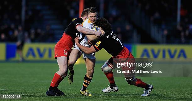Jimmy Gopperth of Wasps is tackled by Nick Tompkins and Jacques Burger of Saracens during the Aviva Premiership match between Saracens and Wasps at...