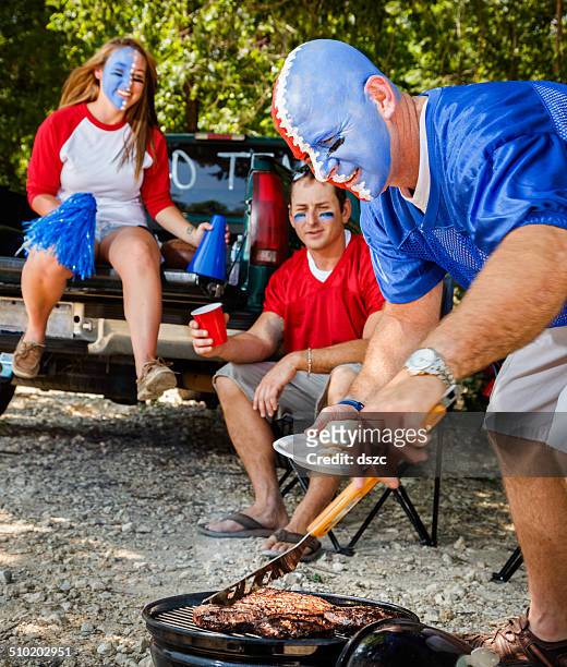 young adult college football fans tailgating with barbeque grilled food - tailgate stock pictures, royalty-free photos & images