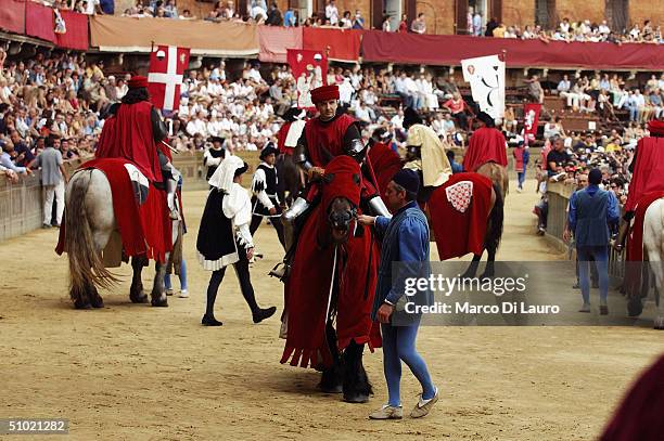 The group of costumed partecipants who represent their Contrada are seen at the historic parade that take place in Piazza del Campo before the Palio...