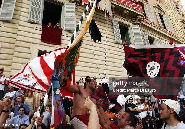 The jockey Alberto Ricceri of Giraffa , one of the seventeen Contrade or neighbourhoods, celebrates with his contradaioli in Piazza del Campo, having...