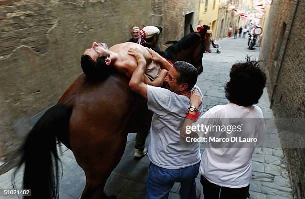 The jockey Alberto Ricceri of Giraffa , one of the seventeen Contrade or neighbourhoods, rests exhausted on his horse, Donosu Tou, as he leavs Piazza...