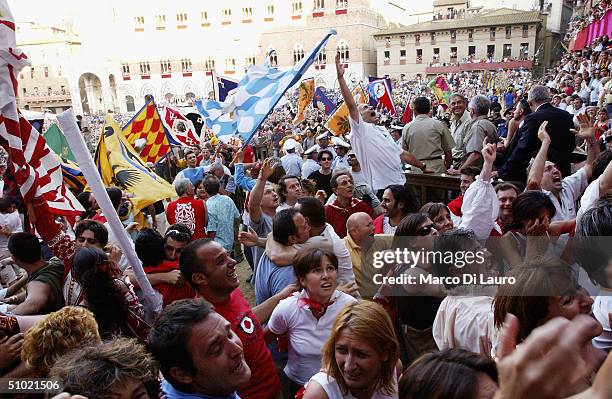 The Contradaioli belonging to the Giraffa , one of the seventeen Contrade or neighborooud, celebrate after their jockey and horse won the Palio horse...