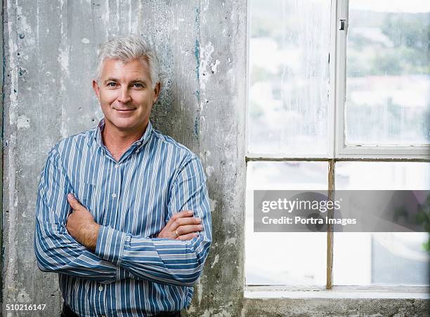 confident businessman standing against wall - open collar stock pictures, royalty-free photos & images