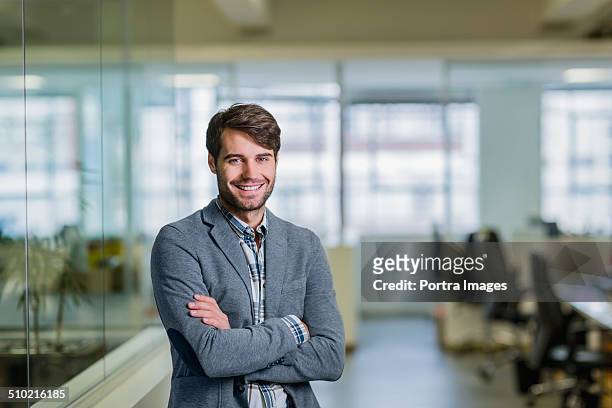 happy businessman standing arms crossed in office - businesswear stock pictures, royalty-free photos & images