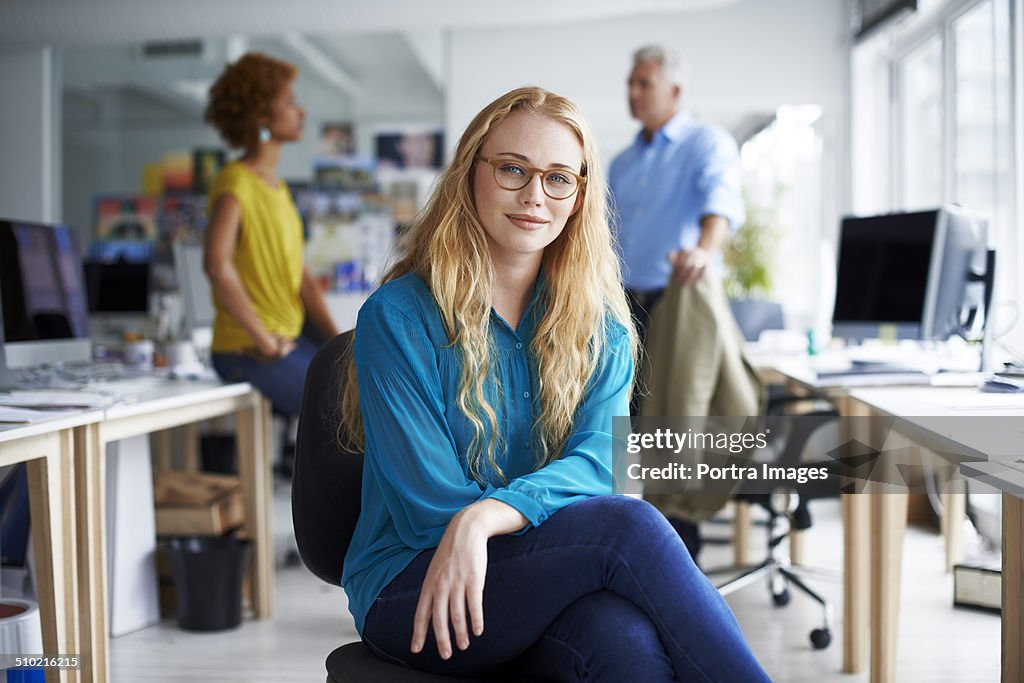 Smiling businesswoman sitting at creative office