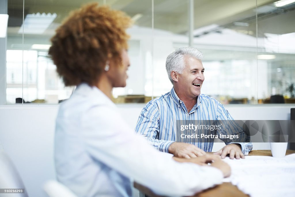 Happy businessman discussing in board room