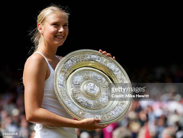 Maria Sharapova of Russia poses with her trophy after she won against Serena Williams of USA in the ladies final match at the Wimbledon Lawn Tennis...