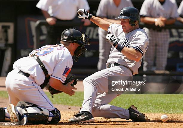 Catcher Jason Phillips of the New York Mets cannot hold onto the ball as John Flaherty of the New York Yankees slides into home for a run in the...