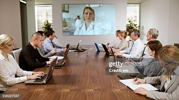 committee having a video conference in the boardroom - group video conference stock pictures, royalty-free photos & images