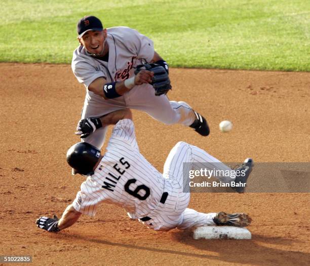 Carlos Guillen of the Detroit Tigers completes a double play against Aaron Miles and Royce Clayton of the Colorado Rockies in the fourth inning on...