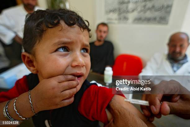 Palestinian child is vaccinated against measles and vitamin A deficiency at Al-Shouhda Rafah health center during the national campain for protection...