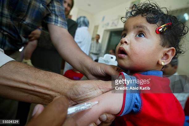 Palestinian child is vaccinated against measles and vitamin A deficiency at Al-Shouhda Rafah health center during the national campain for protection...
