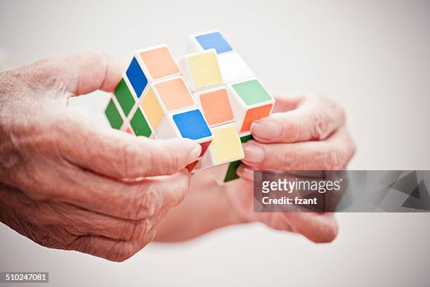 hands playing a game cube - easy solutions fotografías e imágenes de stock