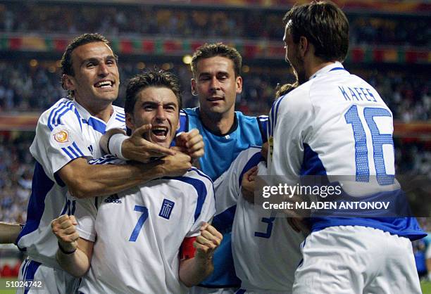 Members of the Greek team celebrate, 04 July 2004 at Stadio da Luz in Lisbon after the Euro 2004 final football match between Portugal and Greece at...