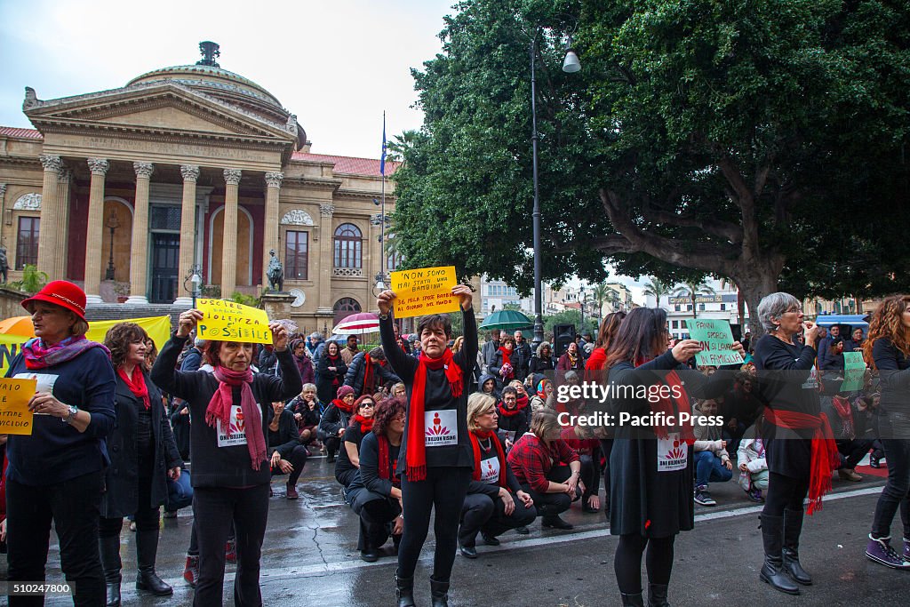 Hundreds of women wearing  black with a red accessory dance...