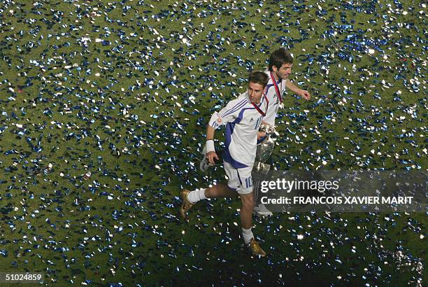 Greece's midfielder Vasileios Tsiartas and Georgios Karagounis run with the cup ,04 July 2004 at Stadio da Luz in Lisbon, after the Euro 2004 final...