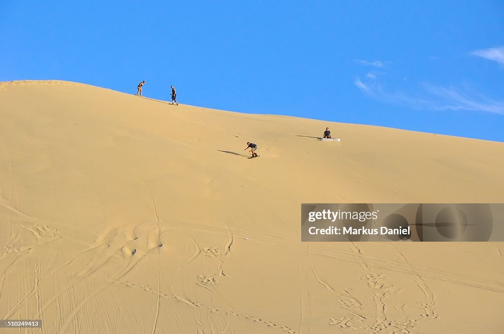 Sand surfing in the dunes near Huacachina, Peru