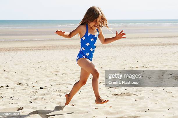 child having fun at the beach - fille maillot photos et images de collection