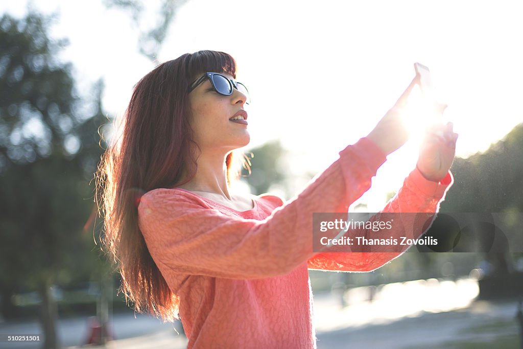 Portrait of a young woman photographing her self