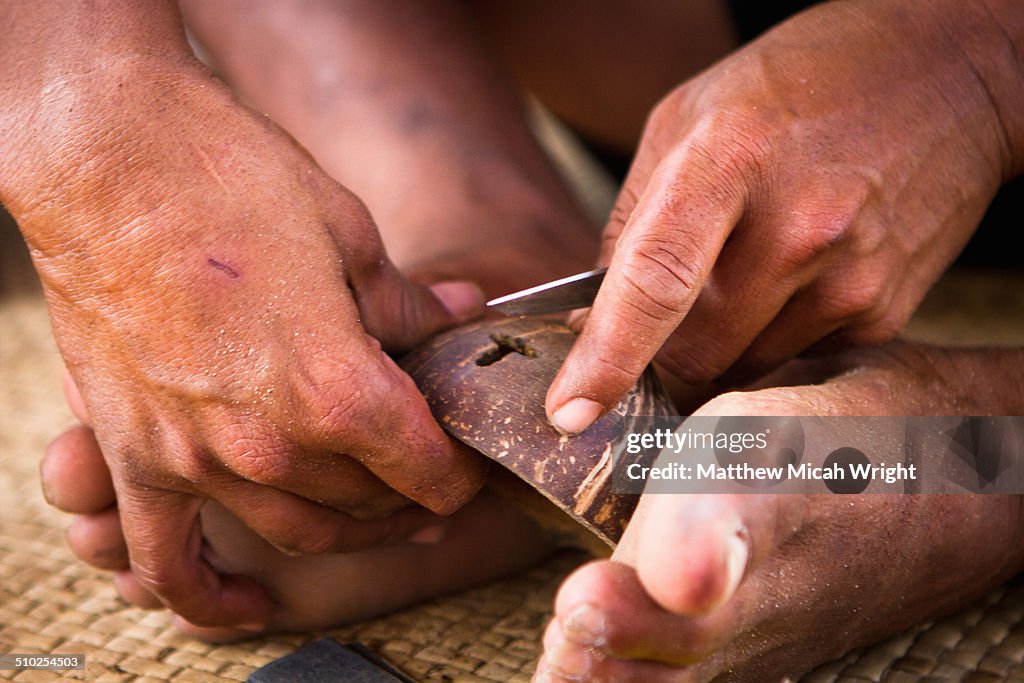 A class carving coconuts into jewelry