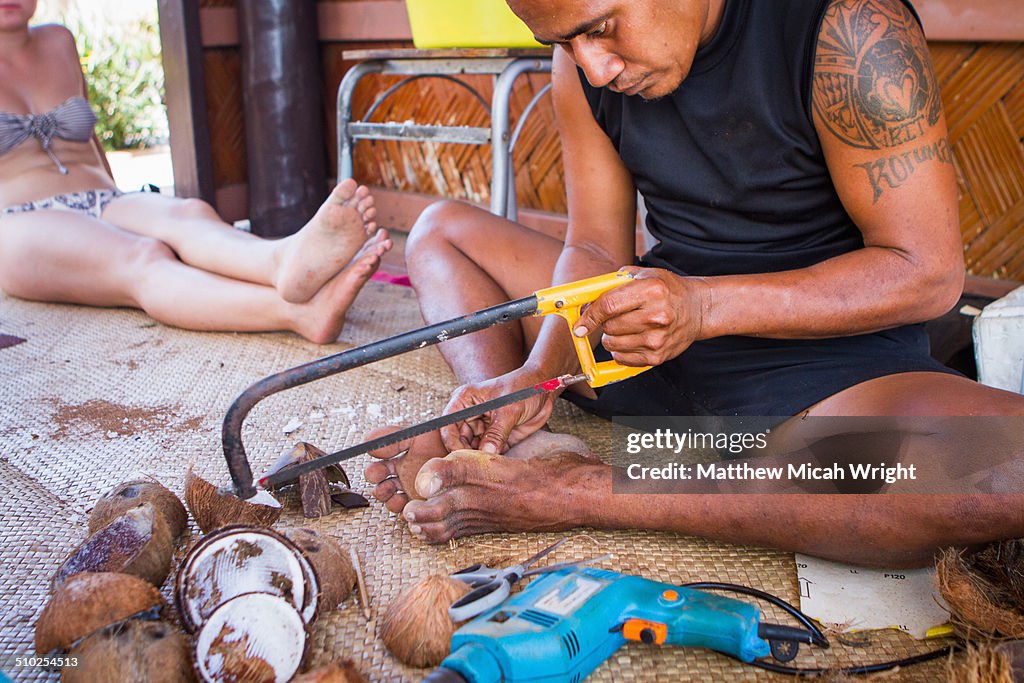 A class carving coconuts into jewelry