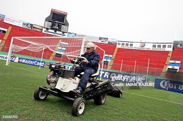 Worker gives the finishing touches to the National Stadium's field 05 July 2004 in Lima, Peru, where different matches of the Copa America football...