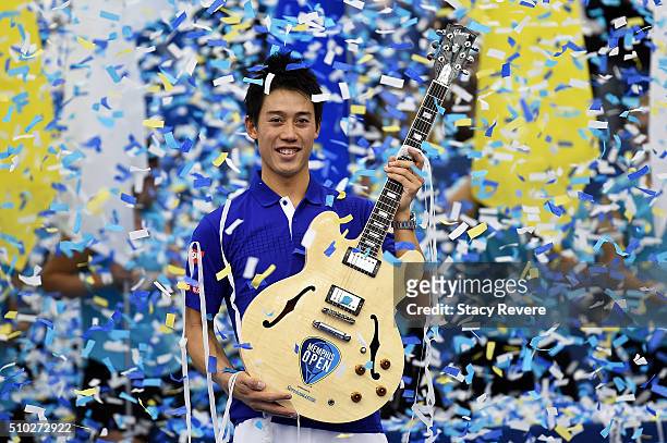 Kei Nishikori of Japan celebrates with the trophy after defeating Taylor Fritz of the United States in their singles final match on Day 7 of the...