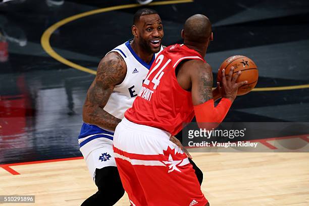 LeBron James of the Cleveland Cavaliers and the Eastern Conference smiles as he defends Kobe Bryant of the Los Angeles Lakers and the Western...