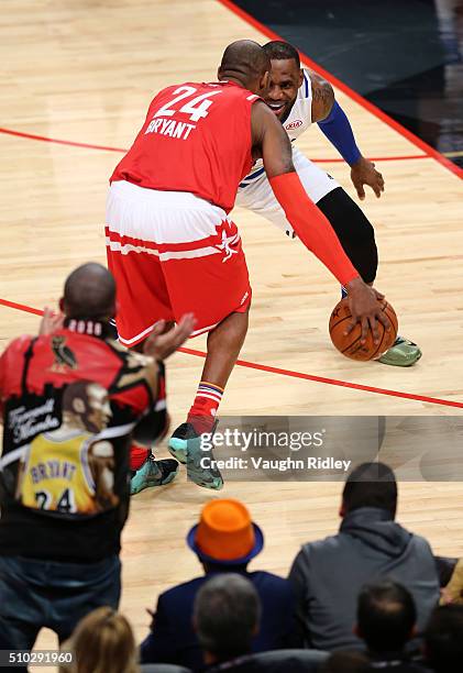 LeBron James of the Cleveland Cavaliers and the Eastern Conference smiles as he defends Kobe Bryant of the Los Angeles Lakers and the Western...