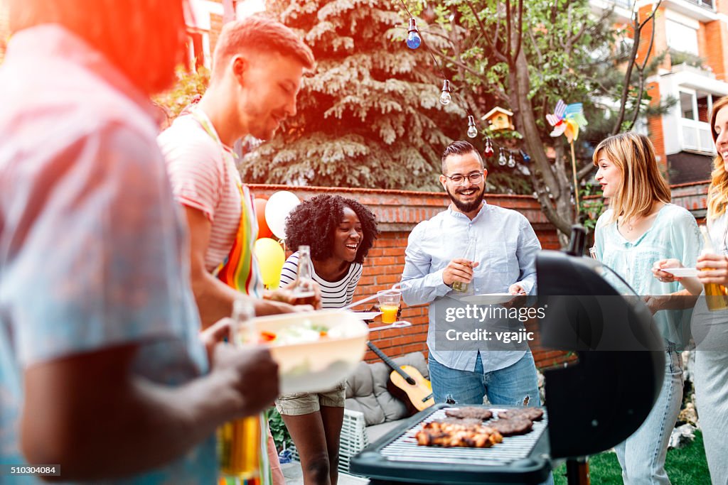 Young People Having Fun At Barbecue Party.