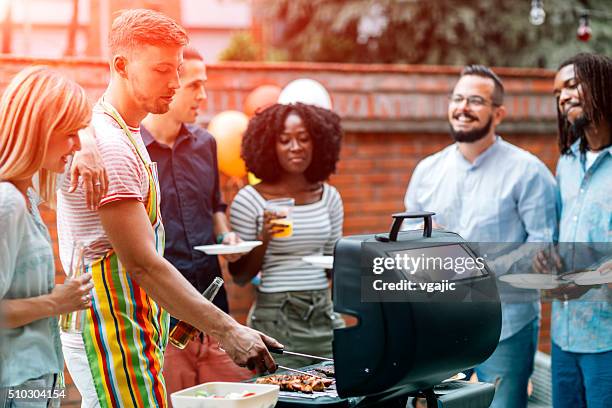 junge menschen havin spaß bei barbecue-party. - couple grilling stock-fotos und bilder