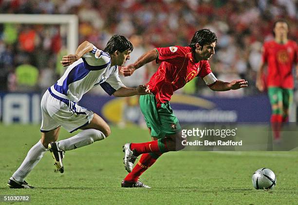 Luis Figo of Portugal evades Panagiotis Fyssas of Greece during the UEFA Euro 2004, Final match between Portugal and Greece at the Luz Stadium on...