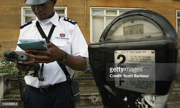 Westminster traffic warden issues a parking ticket on July 7, 2004 in London, England. Money raised in England by parking fines, meters, residential...