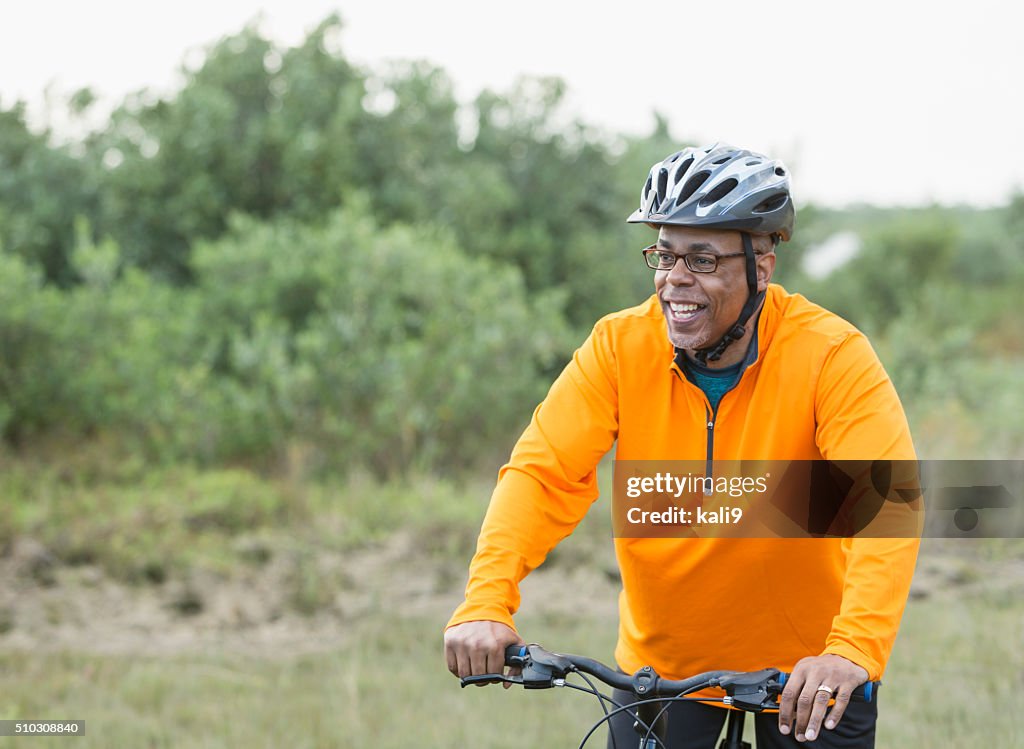 African American man riding bike in park