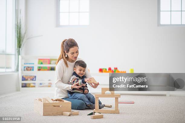 jugando juntos en casa - niño en la sala con juguetes fotografías e imágenes de stock