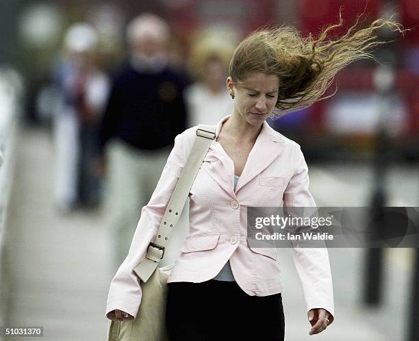 Woman battles gale-force winds as she crosses Waterloo Bridge on July 7, 2004 in London. The high winds heralded the arrival of an unseasonal storm,...