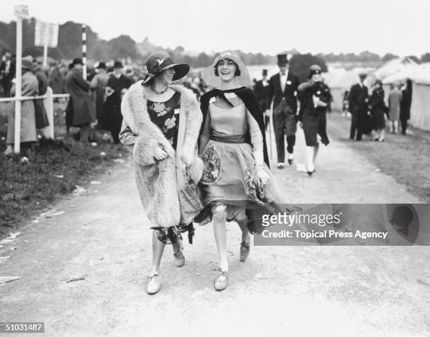 Mrs Norman Holden and Miss Wanda wearing elegant floral dresses with wide-brimmed straw hats at the Royal Ascot horse-racing course near Windsor in...