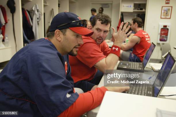 Trot Nixon and Doug Mirabelli of the Boston Red Sox study their at bats on a computer in the locker room before the MLB game against the San...