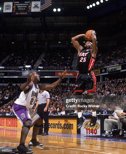 Point guard Anthony Carter of the Miami Heat shoots the ball as guard Bobby Jackson of the Sacramento Kings plays defense during the NBA game at the...