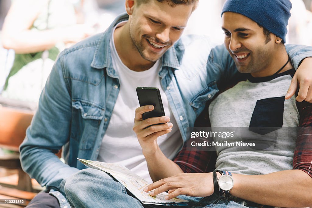 Gay couple sharing something on the cellphone.