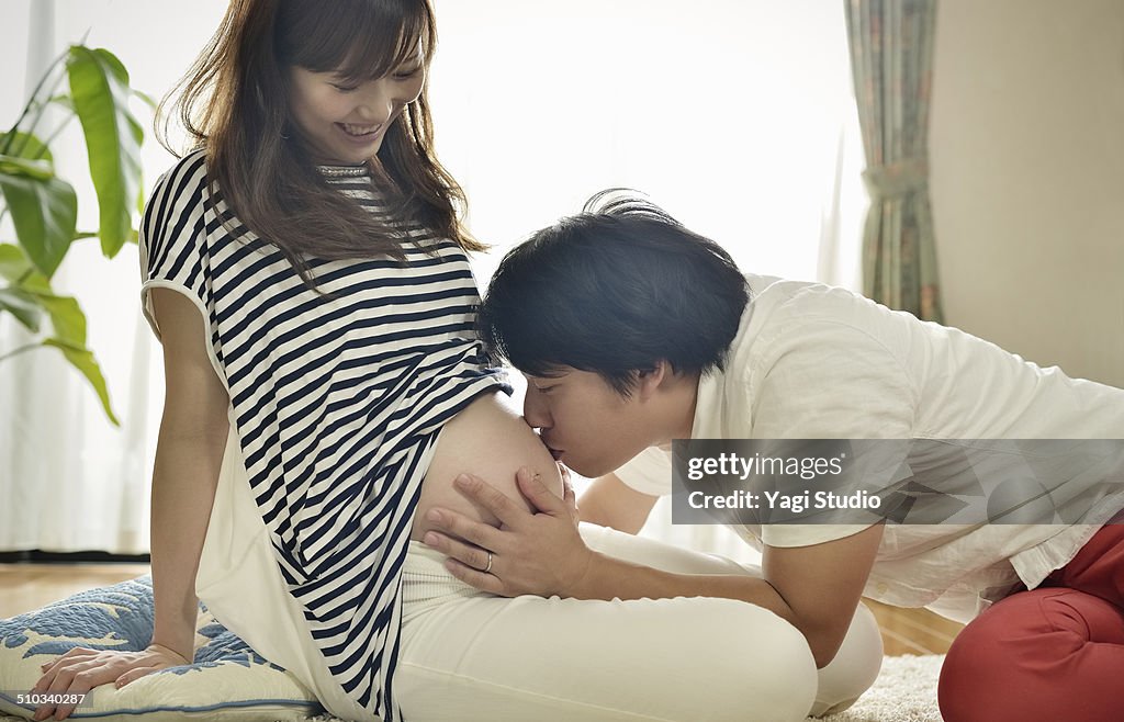 Husband kissing his pregnant wife's belly