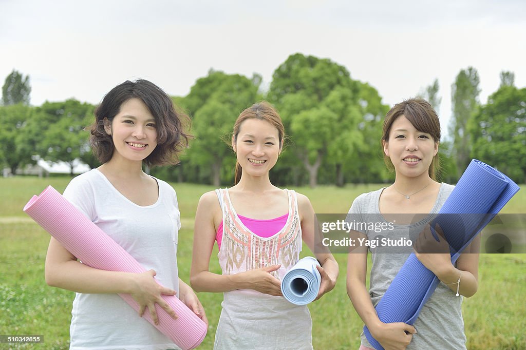 Three women enjoying yoga in park