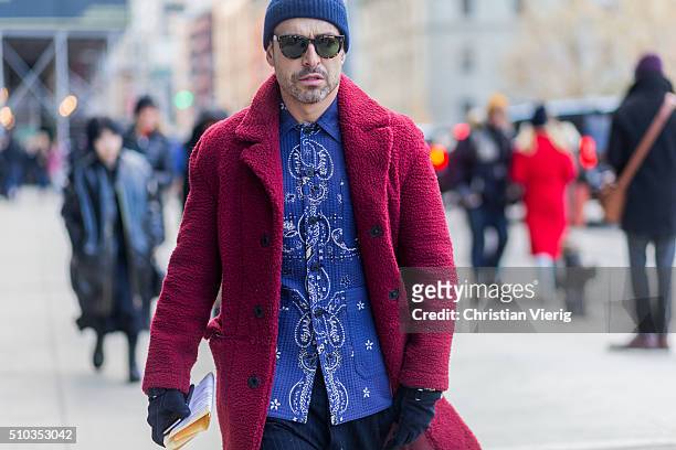Alex Badia is wearing red coat and blue button shirt and knit hat seen outside Lacoste during New York Fashion Week: Women's Fall/Winter 2016 on...