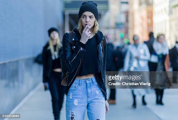 Fashion model wearing ripped blue denim jeans, a black leather jacket seen outside Lacoste during New York Fashion Week: Women's Fall/Winter 2016 on...