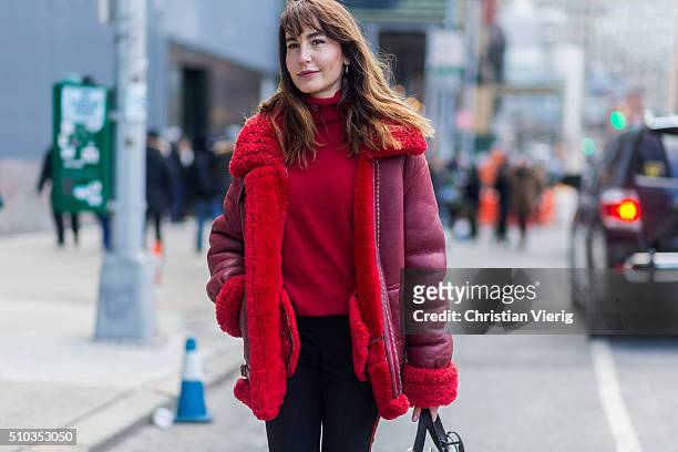 Ece Sukan wearing a red sweater and shearling leather jacket and silver boots seen outside Lacoste during New York Fashion Week: Women's Fall/Winter...